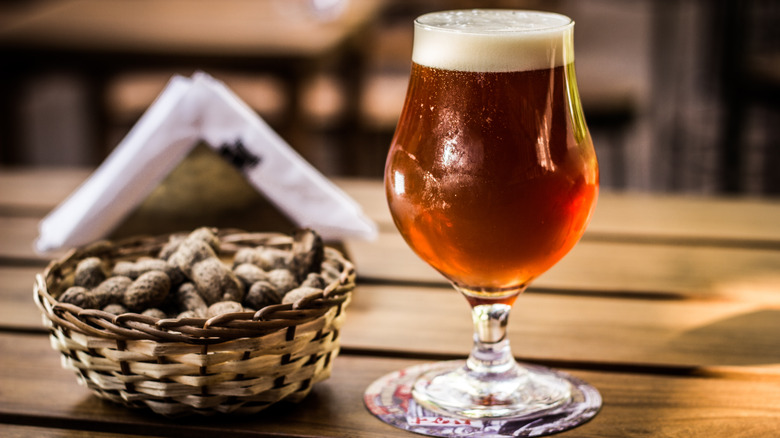 Barleywine in a tulip glass next to a basket of peanuts