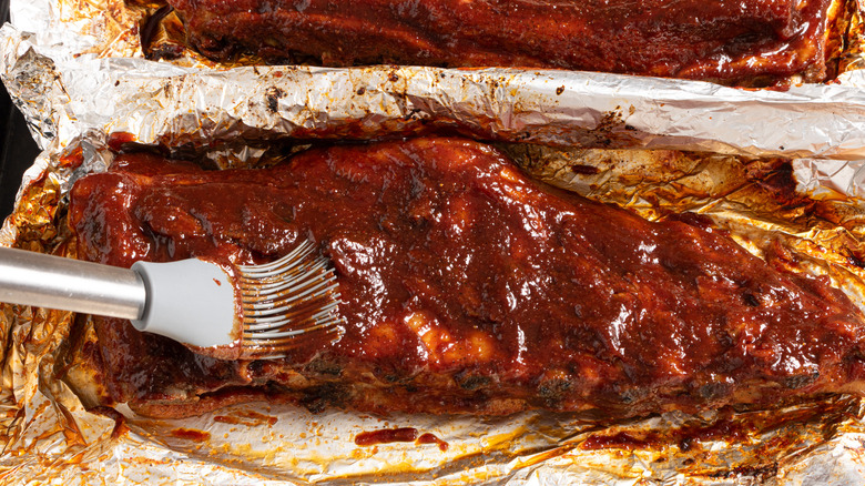Brushing ribs with bbq sauce