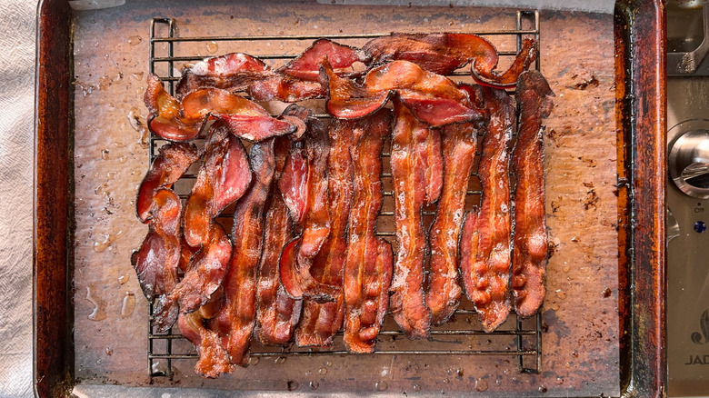 Crisp baked bacon on baker's rack over parchment on baking pan