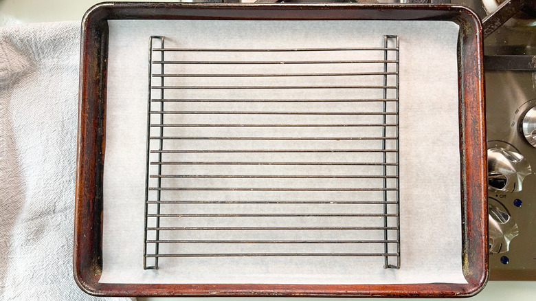 Baking sheet lined with parchment paper and a baker's rack