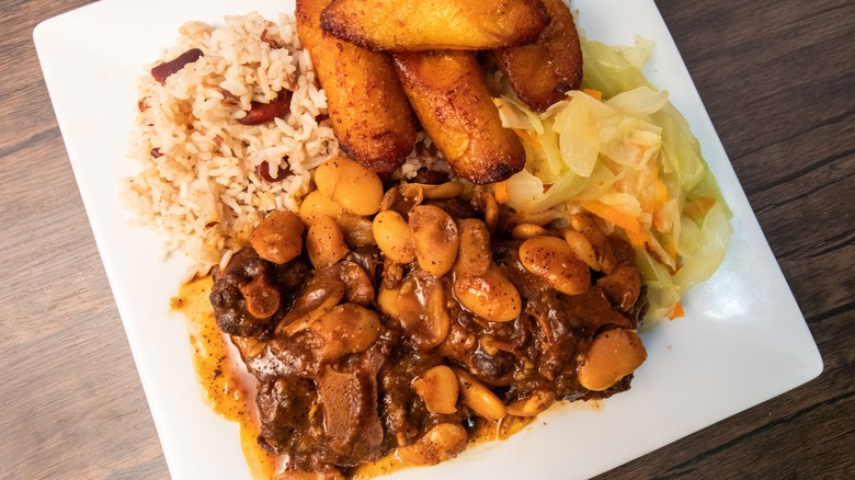 A plate of Jamaican-style braised oxtail, rice, cabbage, and plantains