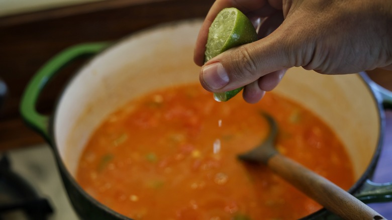 squeezing lime into tomato bisque