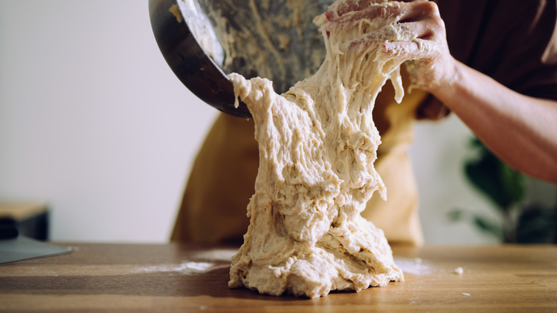 Sticky bread dough being poured onto a work surface