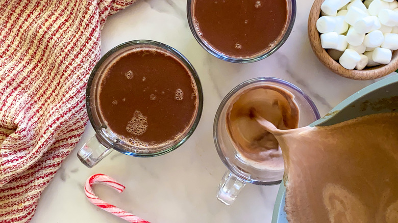 pouring hot chocolate into glass cups