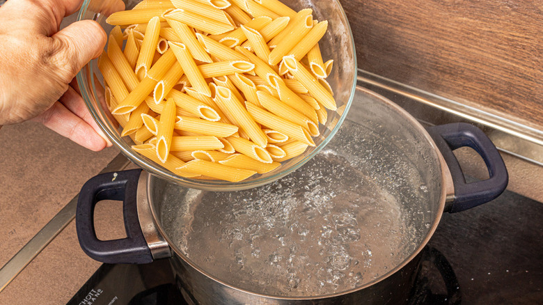 penne pasta going into boiling water