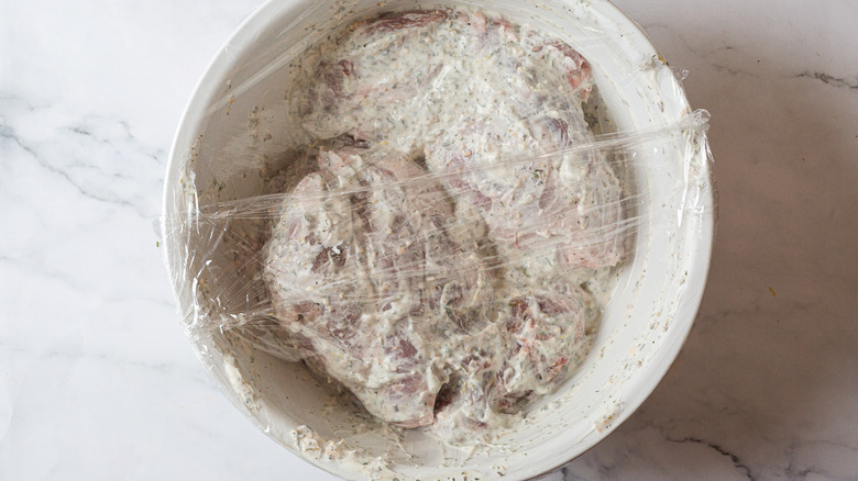 Marinated lamb covered with plastic wrap