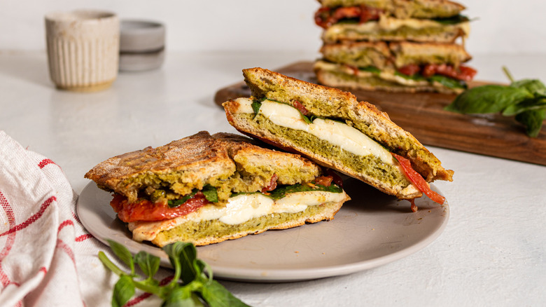 Two slices of pesto caprese panini served on a plate
