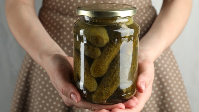 woman holding jar of pickles 