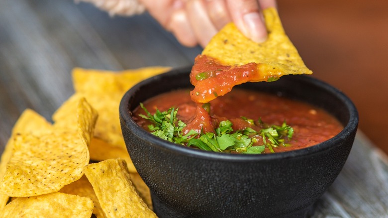 Chip dipped in red salsa