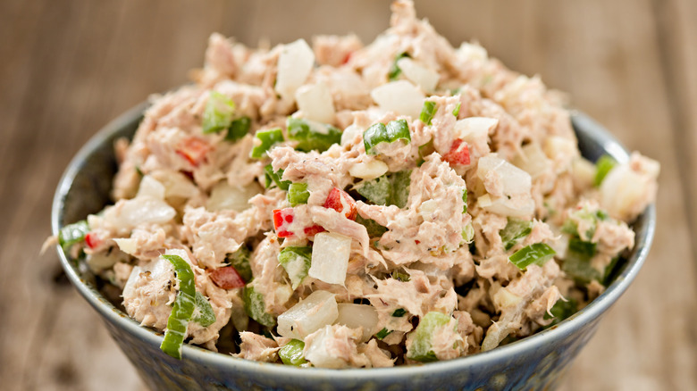 A bowl of tuna salad with fresh red peppers, green onion, and celery