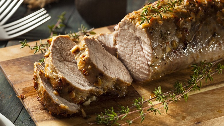 Pork tenderloin displayed on a wooden cutting board