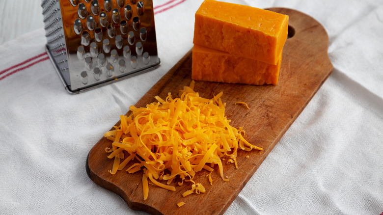 Cheddar cheese on cutting board