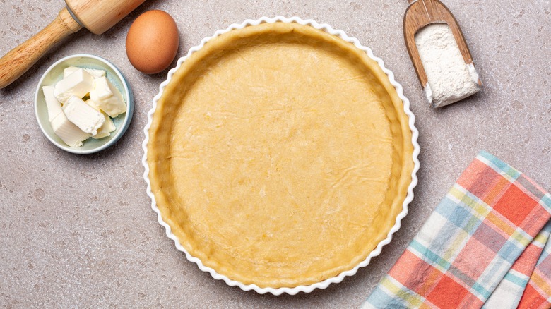 Empty unbaked pie crust and ingredients