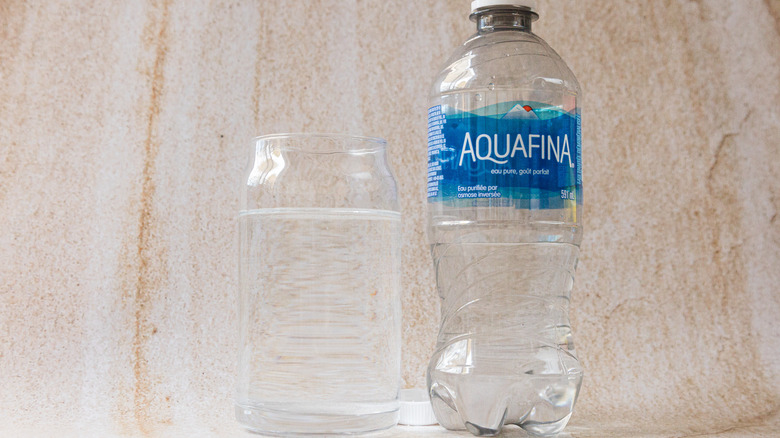 Bottle of Aquafina besides glass