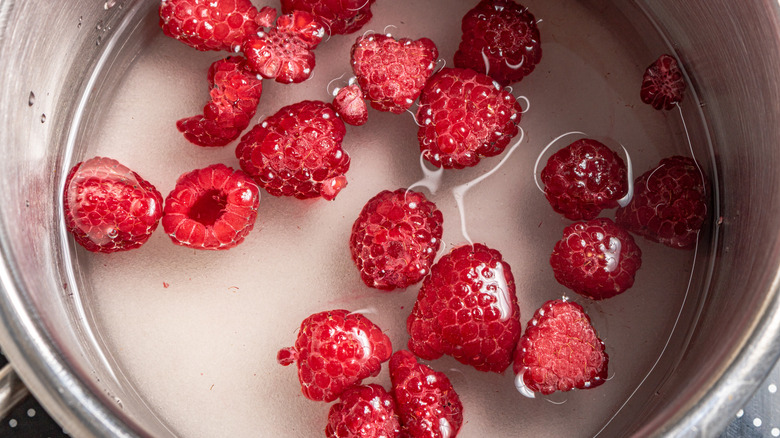 Raspberries, sugar, and water in a saucepan