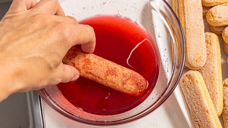 Dipping ladyfingers in raspberry syrup