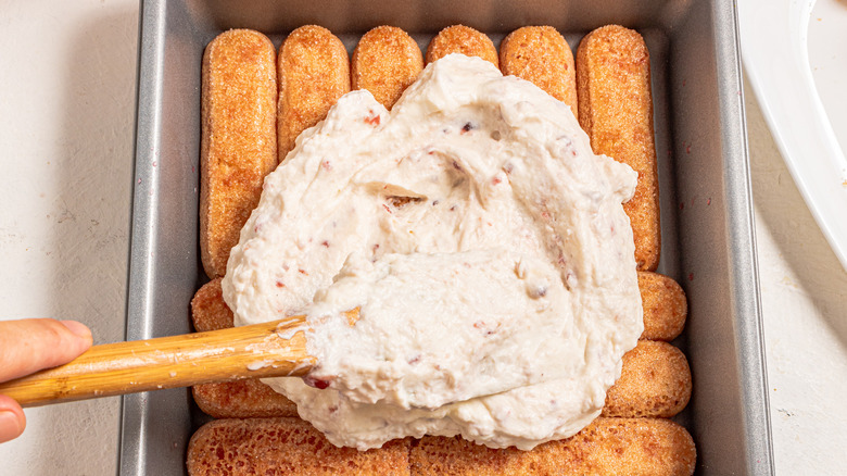 Spreading mascarpone cream on top of ladyfingers