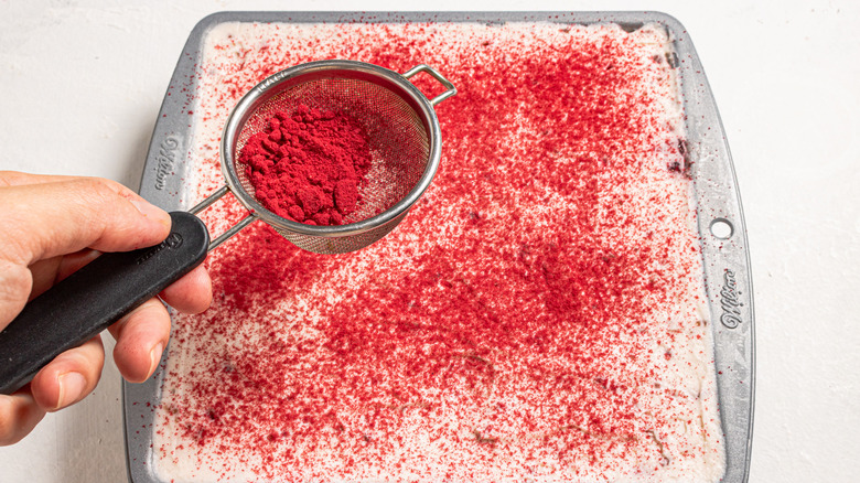 Sifting raspberry powder over tiramisu