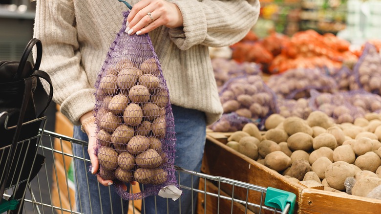 Woman picking potatoes at market