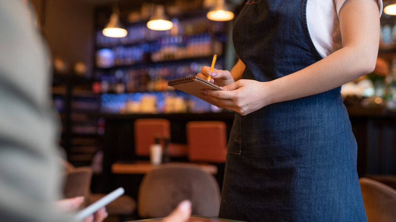 Server in apron taking an order