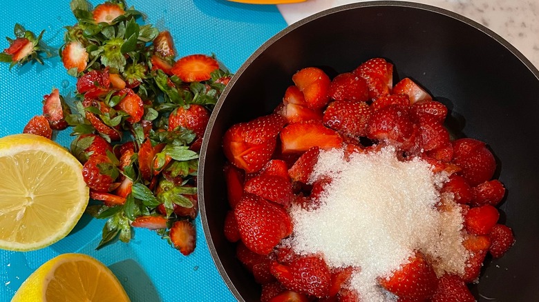 Pot of fresh berries, sugar, and lemon