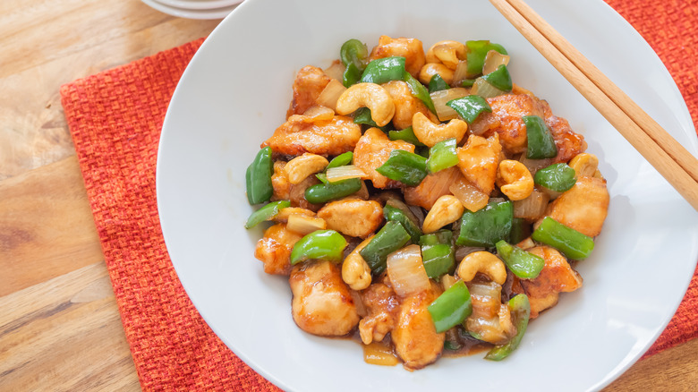 A bowl of cashew chicken with onions and green bell peppers