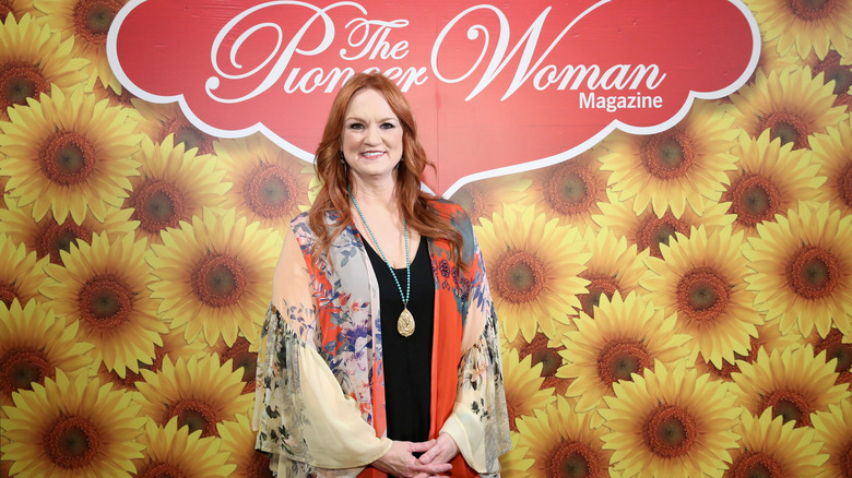 Ree Drummond, the Pioneer Woman, stands in front of a sign with her brand's name