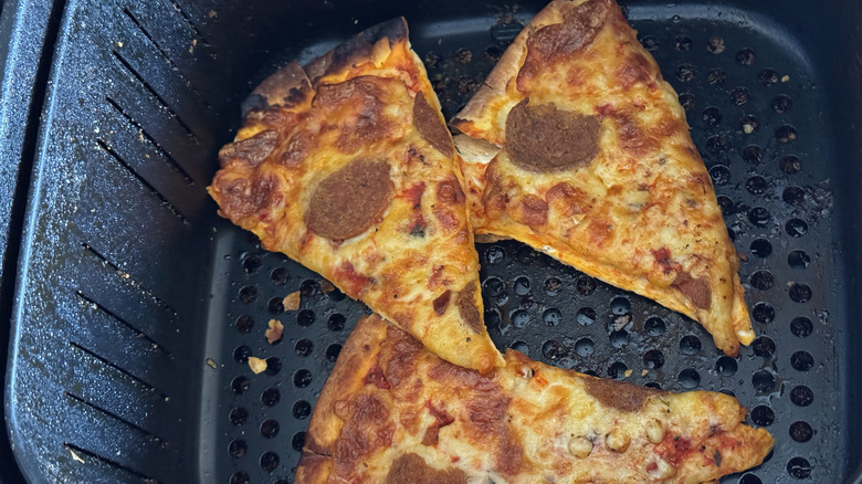 slices of pizza in air fryer basket