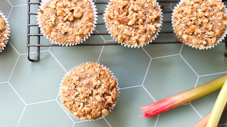 Rhubarb and cardamom oat muffins on cooling rack and countertop