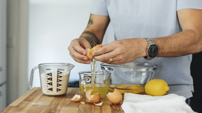 Man cracking eggs into a bowl