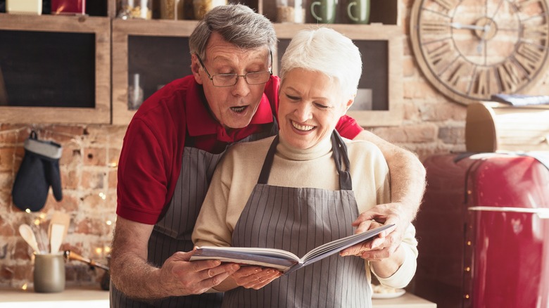 Man and woman reading recipe book