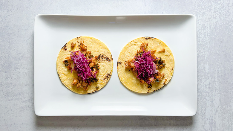 Red cabbage slaw on two cauliflower tacos