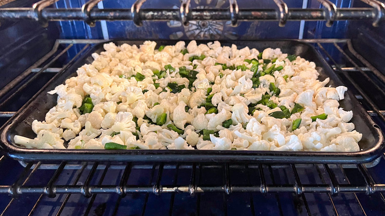 Cauliflower and poblano peppers baking sheet in oven