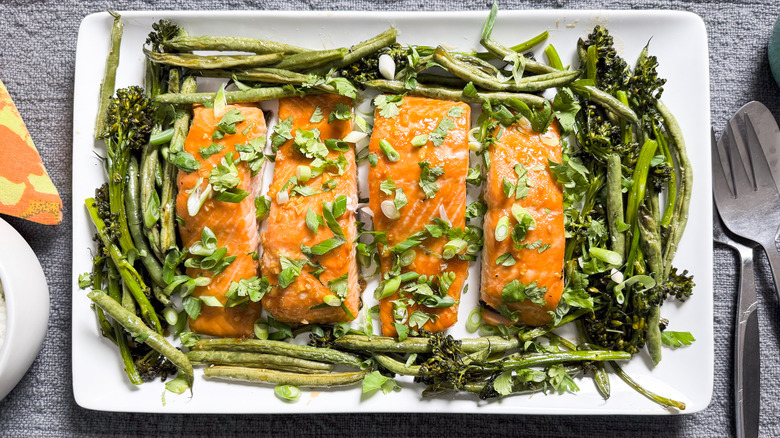 Roasted miso maple salmon on serving platter with green beans, broccolini, and scallions