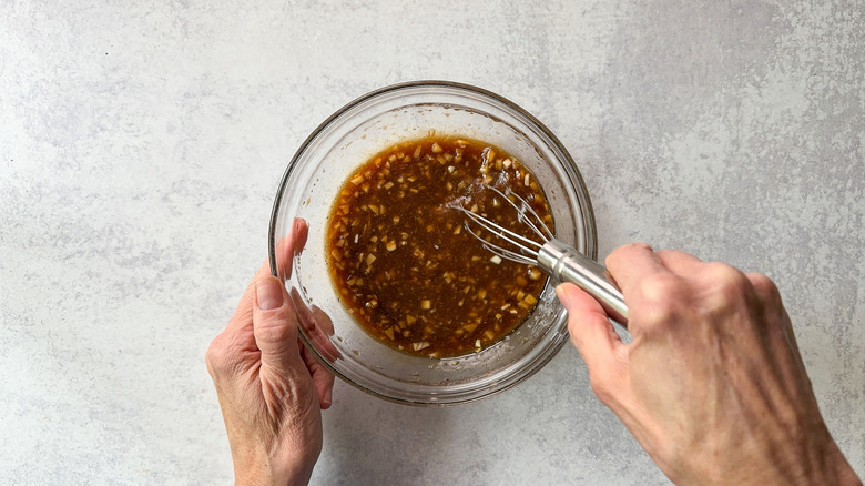 Whisking miso maple salmon marinade in glass bowl