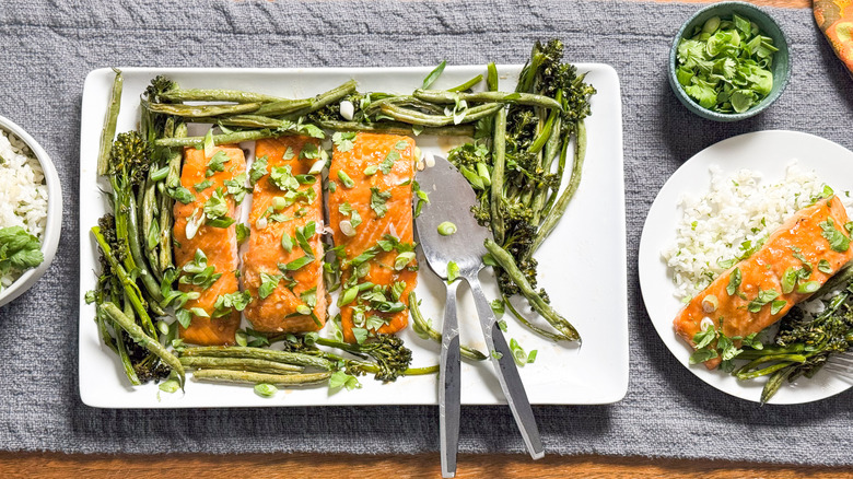 Roasted miso maple salmon with broccolini and green beans on serving platter with cilantro rice and scallion cilantro garnish