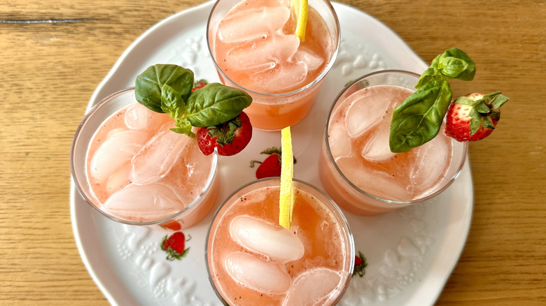 pink lemonade garnished with strawberries and basil