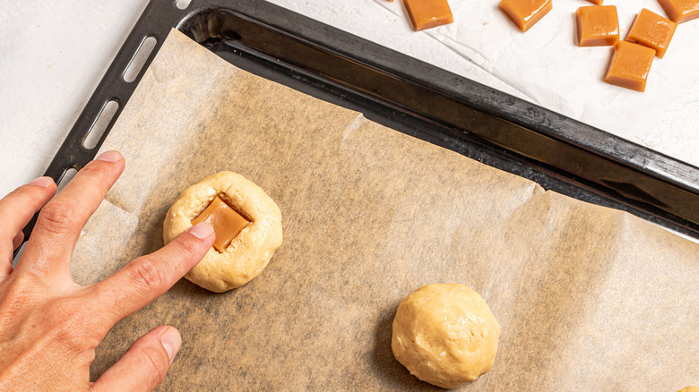 Pressing caramel into cookie dough ball