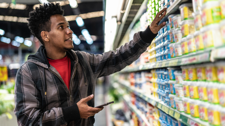 A man looking at butter at the store