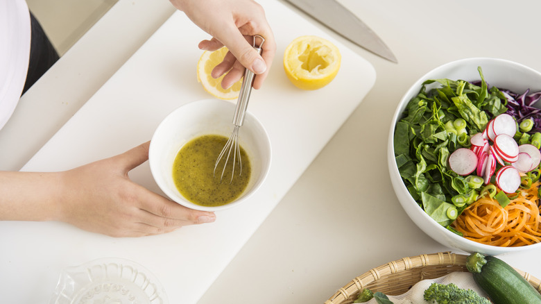 person whisking a salad dressing