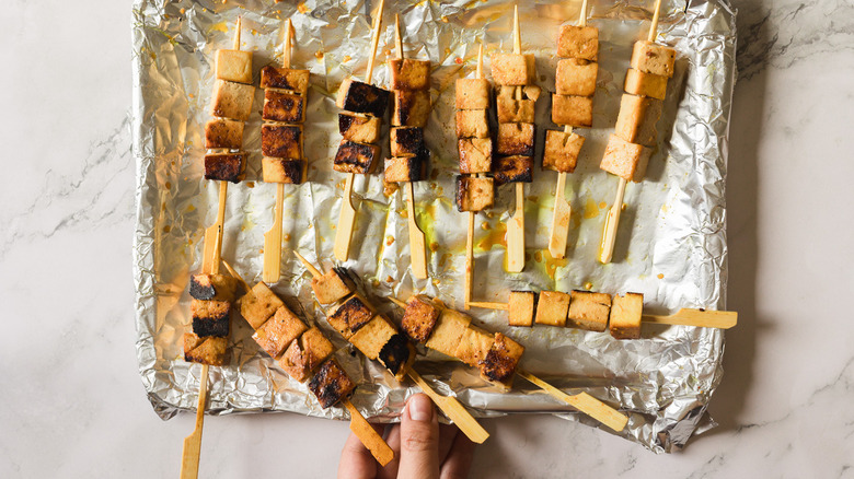 grilled tofu skewers on aluminum covered baking sheet