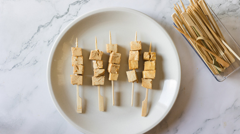 tofu on skewers on white plate