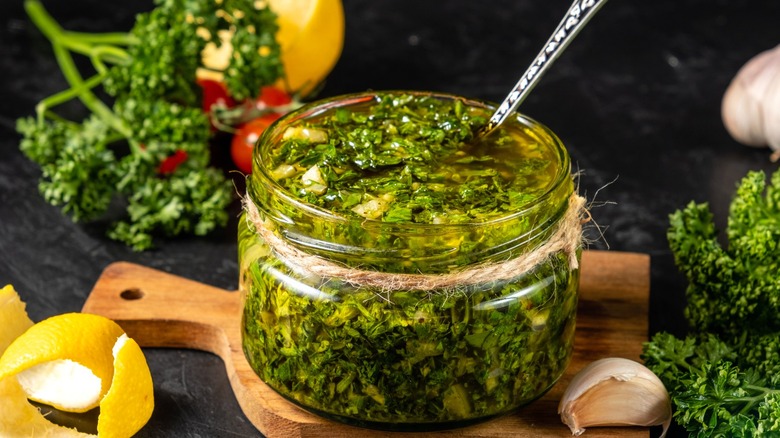 Herbal marinade or sauce in jar with ingredients