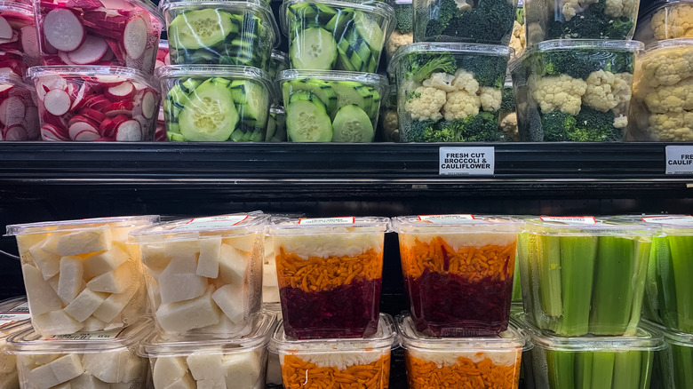 Grocery store shelves with precut produce in plastic containers