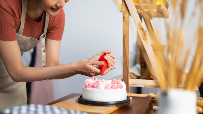 Person decorating cake at home