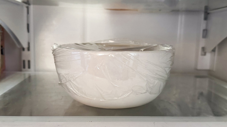 Bowl wrapped with plastic in refrigerator