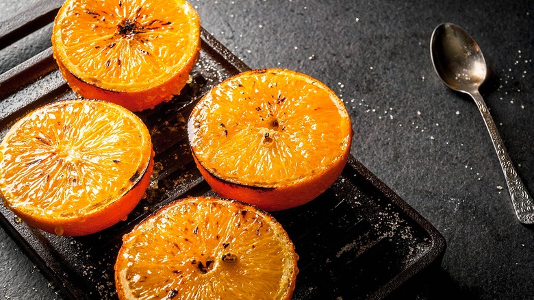 Seared halved oranges on a cast iron hot plate