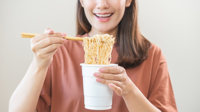 woman eating instant noodles