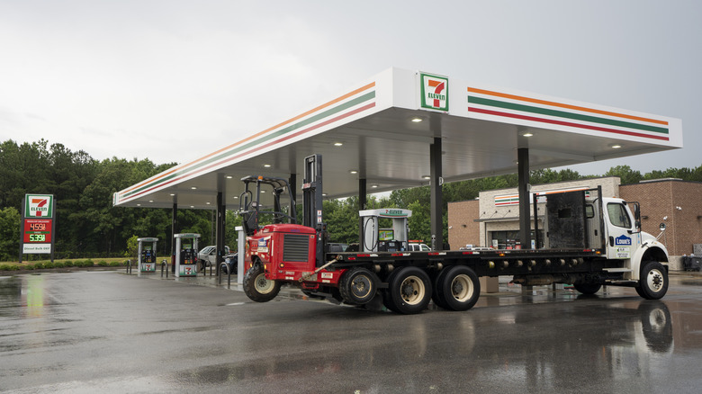 A 7-Eleven gas station with a large truck at the pump