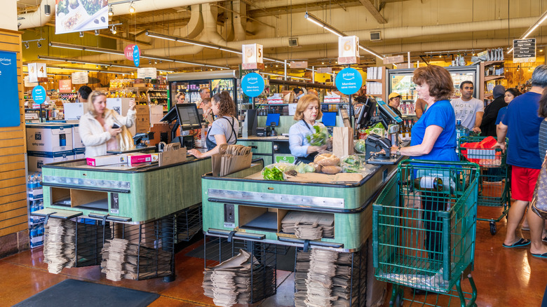 The checkout at Whole Foods Market with two employees ringing up groceries